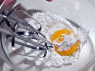 自制沙拉酱,将糖粉加到蛋黄里，用电动打蛋器打发。