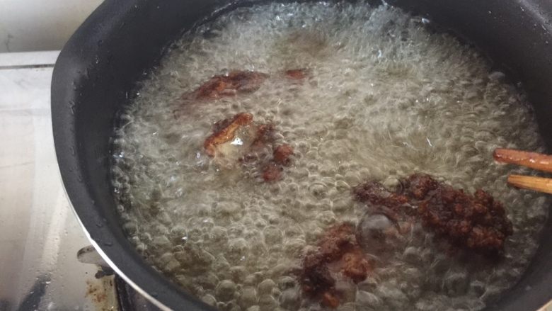 超详细又简单的椒盐排骨,再次将锅里的油烧热，中高火倒入排骨，进行第二次油炸。这一步是为了排骨的外壳松脆。炸2分钟后关火。