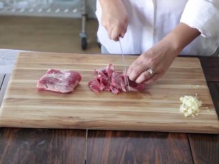 15分钟一道家常西兰花炒牛肉,将牛肉切片，放在一个碗里，蒜切碎