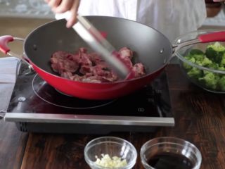 15分钟一道家常西兰花炒牛肉,加入腌制好的牛肉，让牛肉铺在锅的整个表面
