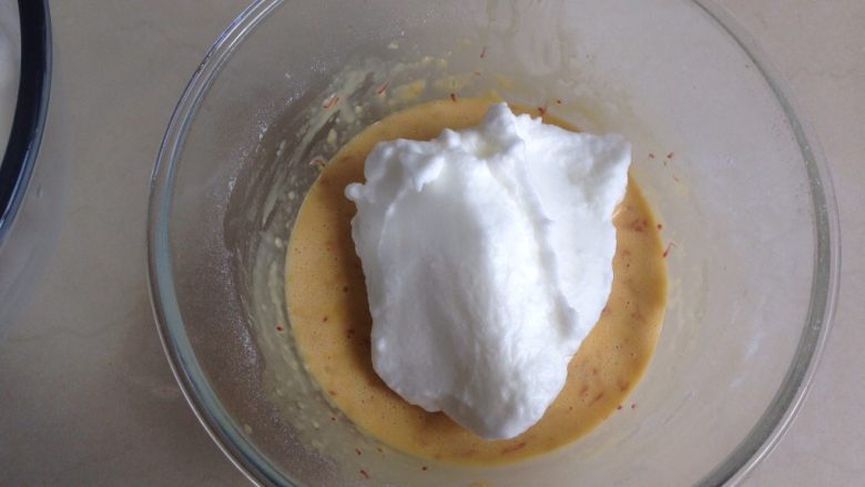 杨梅酱蛋糕卷,将三分之一打发好的蛋白霜放入到蛋黄糊里
