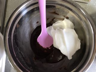 芒果芭菲冰淇淋蛋糕,取三分之一蛋白霜加入可可糊，翻拌均匀。