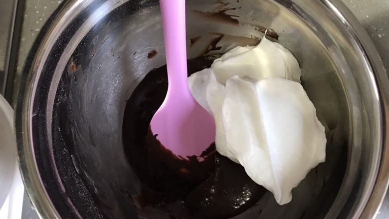 芒果芭菲冰淇淋蛋糕,取三分之一蛋白霜加入可可糊，翻拌均匀。