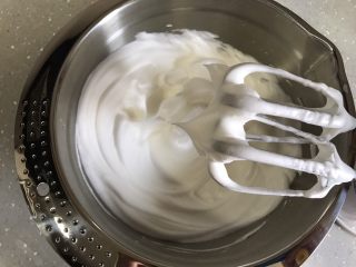 芒果芭菲冰淇淋蛋糕,蛋清分三次加入细砂糖，打发至硬性发泡，提起打蛋头有直立小尖角状态。