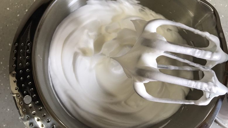 芒果芭菲冰淇淋蛋糕,蛋清分三次加入细砂糖，打发至硬性发泡，提起打蛋头有直立小尖角状态。