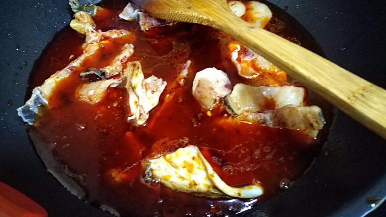麻辣片片鱼,把鱼头、鱼骨翻炒几下后，加入清水。把鱼头、鱼骨煮开。