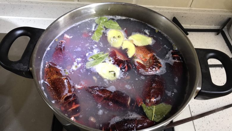 麻辣小龙虾 家常版,烧一锅水，水开后放入生姜片香叶，再放入清洗干净的小龙虾和钳子，放一点料酒或是白酒去腥。水再次开了以后关火捞起小龙虾。