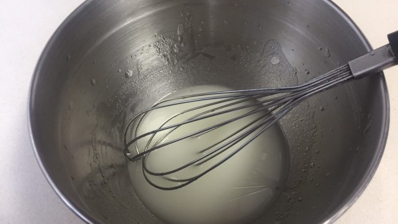 可可旋风瑞士卷（后蛋法）,水和油倒进打蛋盆里进行乳化，手动打蛋器搅拌均匀呈乳白状，多搅拌一会，让水和油充分融合在一起。