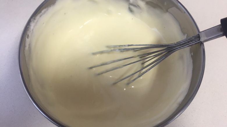 可可旋风瑞士卷（后蛋法）,取出三分之一的蛋白霜到蛋黄糊里，用翻拌的手法把两者混合均匀。
