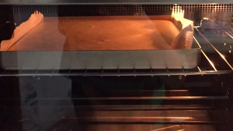 可可旋风瑞士卷（后蛋法）,划好后稍微抹平表面，烤盘在台面上振几下，这样可以振出蛋糕糊中的大气泡，送入提前预热好的烤箱，上下火160度烤25分钟左右。