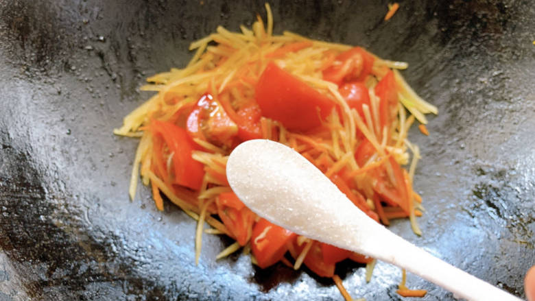 西红柿炒土豆丝,一勺糖，然后翻炒均匀，待西红柿出汁水后即可出锅～