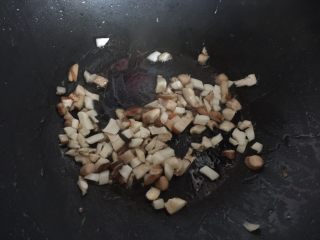 鸡腿包饭,锅里热油后放入香菇和杏鲍菇粒炒至干香