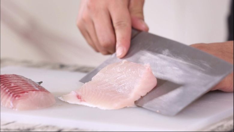 芝麻鱼条,第一步改刀鱼段，先去皮，用刀刃贴近鱼皮，先切一点鱼皮下来，再用力拉鱼皮，这样就可以轻松的取下鱼皮
