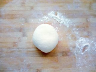 松软汉堡胚,案板上撒面粉，把发酵好的面团排气滚圆