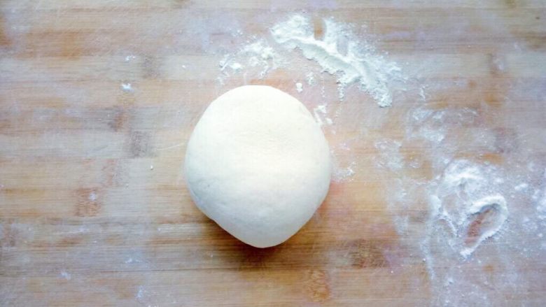 松软汉堡胚,案板上撒面粉，把发酵好的面团排气滚圆