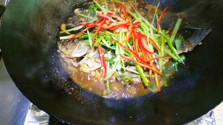 豆瓣鲫鱼,大约二分钟后放入青红椒丝和芹菜，大火收汁加入鸡精。
