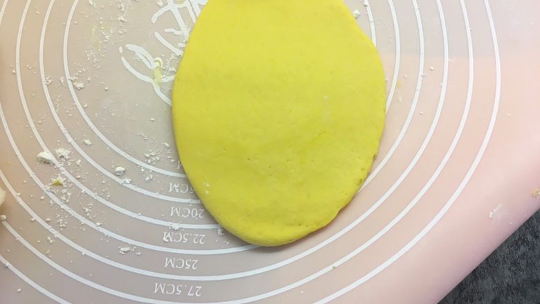 南瓜荷叶饼,取一个面团压扁，用擀面杖擀成椭圆形