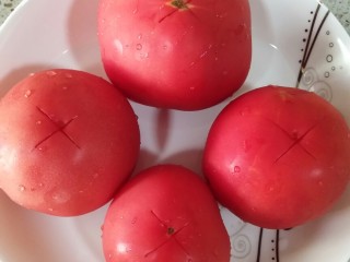 西红柿炖牛腩,接下来准备西红柿，西红柿上面切十字
