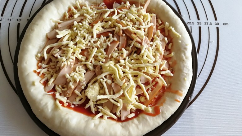虾仁&脆皮肠披萨,再撒一层马苏里拉碎。