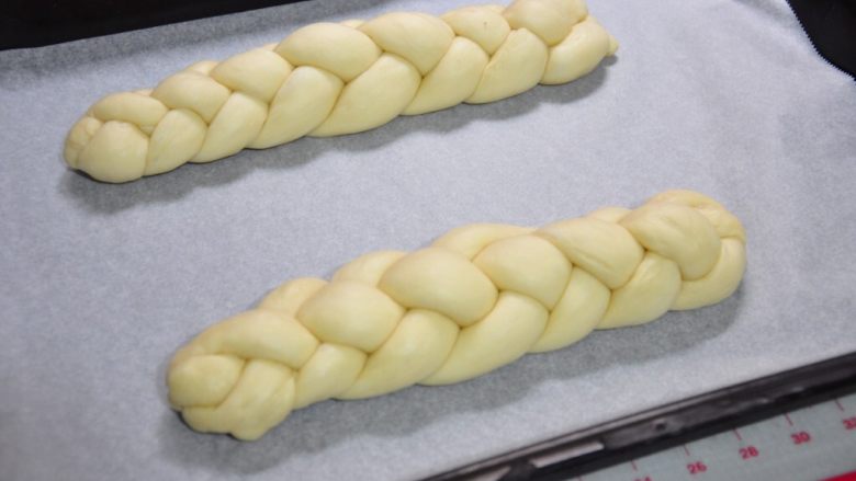 酸奶辫子面包,编好的面团放到烤盘上，覆盖保鲜膜进行最后发酵，约30分钟（面团呈2倍大）。