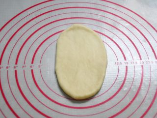 酸奶辫子面包,取一个面团擀成椭圆形。
