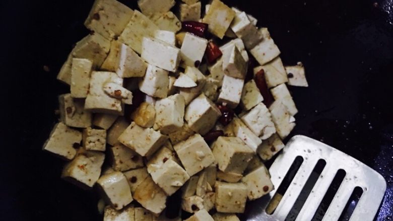 椒盐豆豉烧豆腐,用铲子上下翻动豆腐