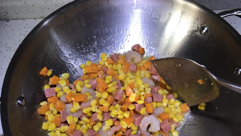 虾仁玉米胡萝卜,再加入火腿肠炒一会，最后加入虾仁，炒至变色。最后加适量盐和糖翻炒一会。关火起锅！