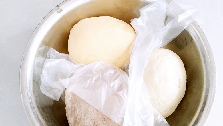 三色卷馒头,三中面团用干净的方便袋区分，盖上个锅盖进行发酵。