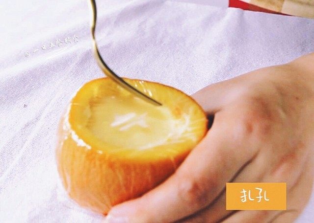 甜橙牛奶蛋羹,橙碗蒙上保鲜膜，用牙签在保鲜膜上扎几个洞。
🌻小贴士：柚子妈第一次蒸没用保鲜膜，直接用甜橙切下来的盖，由于蛋液有点多，最终漫出来好多。