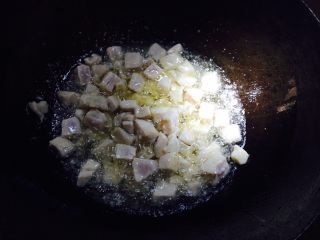 宫保鸡丁,把腌好的鸡丁滑入热油内开火，翻炒至变色发白