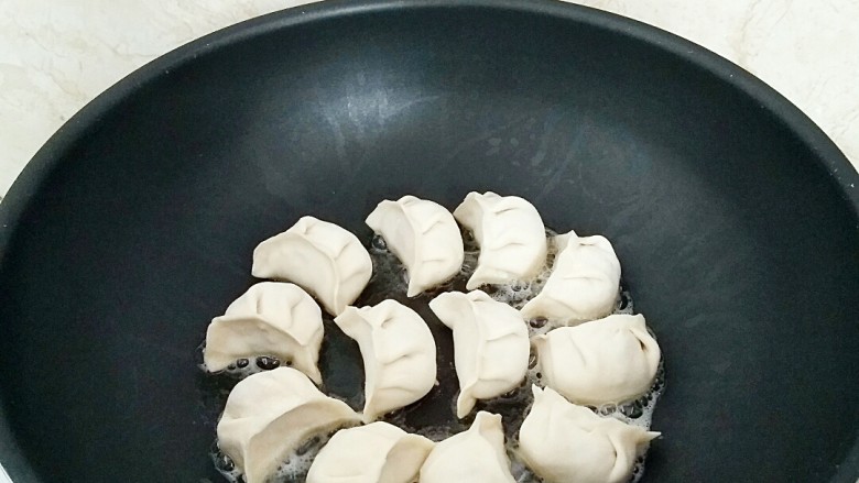 鲜肉灌汤煎饺,煎锅刷2汤匙油烧热，摆放煎饺。