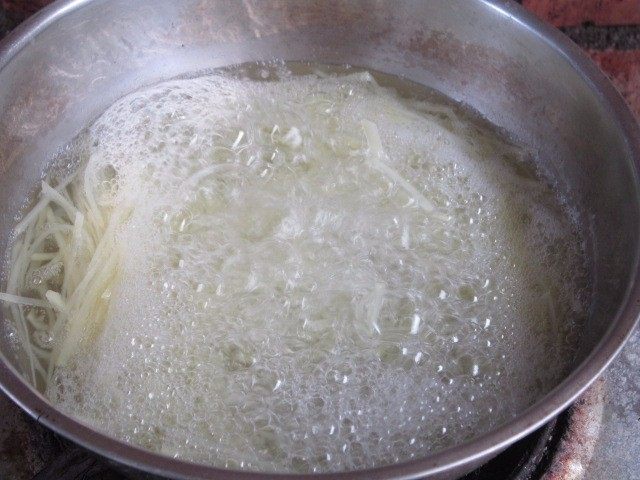 土豆丝卷饼,煮锅沸水，下入土豆丝焯2分钟。