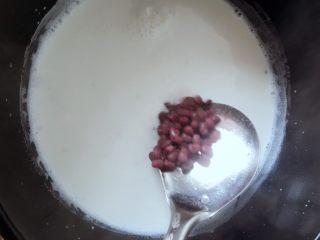 红豆椰奶西米露,然后放入待用的红小豆，汤勺搅拌关火
