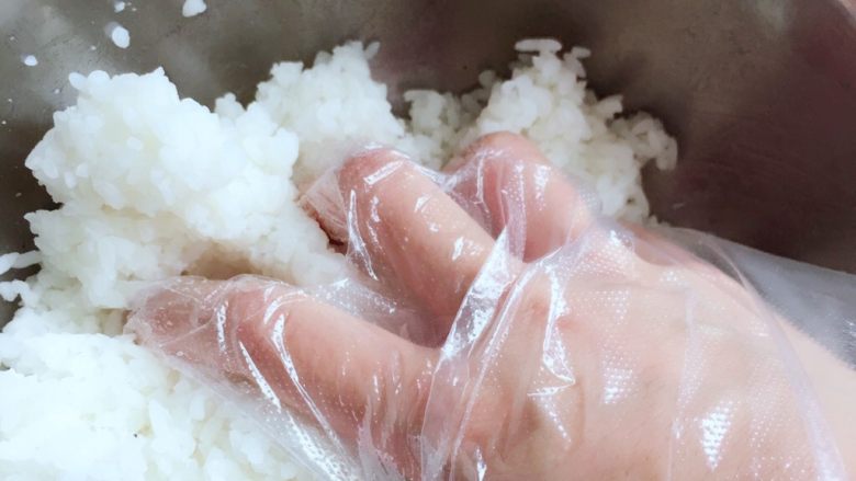 紫菜包饭,将寿司醋适量加入米饭中，戴上一次性手套抓饭