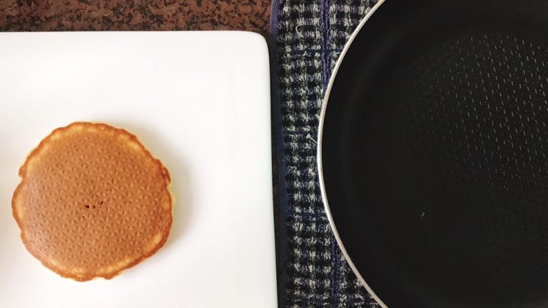 Pancakes热香饼/小松饼,熟了的小松饼是能在平底锅中自由滑动无阻的，很容易就能滑动到盘子里，然后平底锅放到湿抹布上“滋啦”一声开始降温。