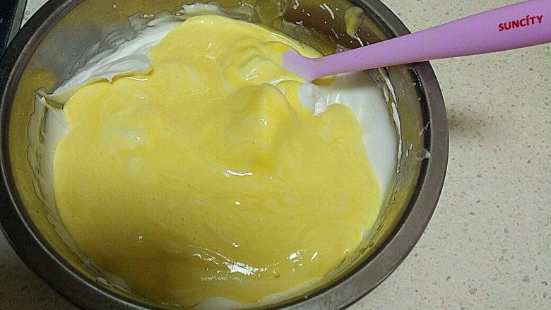酸 奶 小 蛋 糕 ,把搅拌好的面糊倒入剩下的3分之2蛋白里，翻拌搅拌。让蛋白和面糊融合。