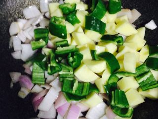 异域风情菜—咖喱土豆牛肉煲,待洋葱炒出香味，加入青椒土豆翻炒