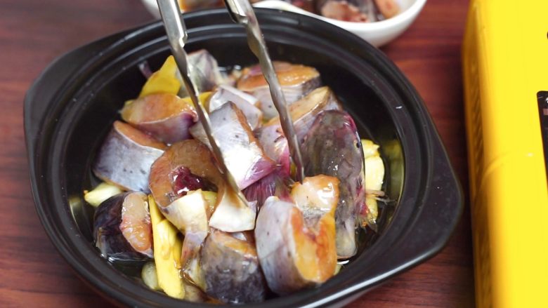 砂锅蒜香焖鮰鱼,将腌制好的鮰鱼平铺在蒜子上
