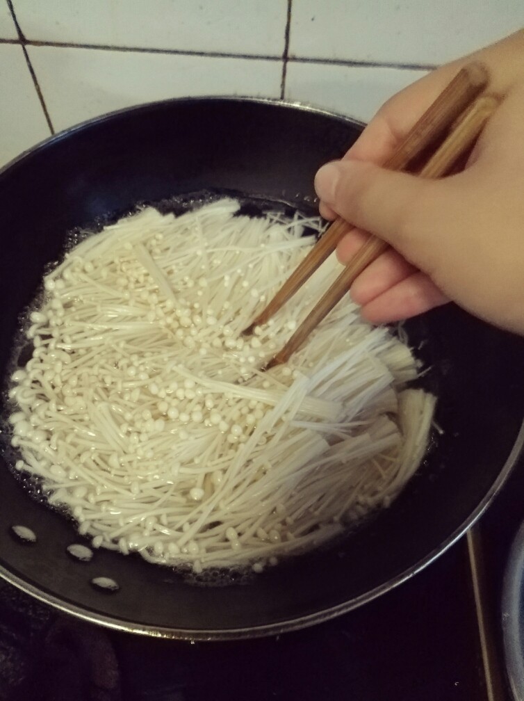 香辣凉拌金针菇,用筷子搅匀，烫一分钟左右，时间不宜过长