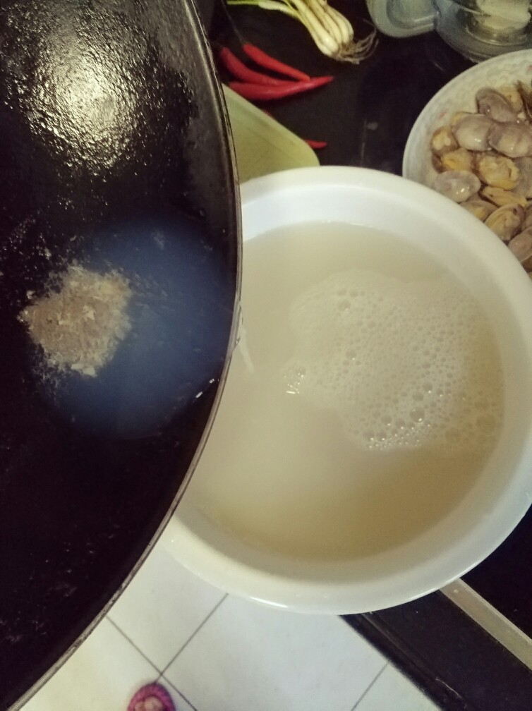 香辣爆炒花甲,沉淀好的花甲汤倒在干净的碗里备用