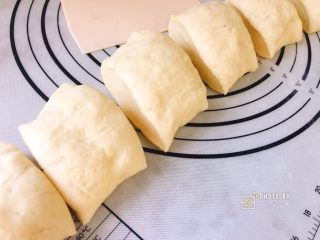椰香四溢的软绵绵椰蓉面包,排完气揉成长条状，用刮板分割成6等份。