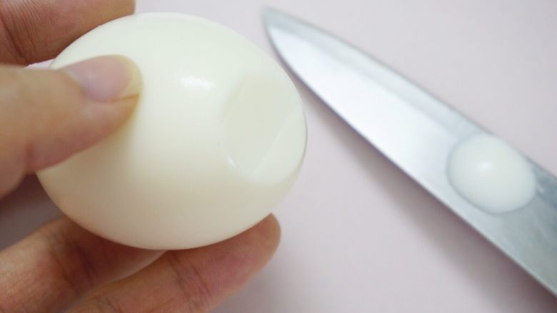 呆萌小黄鸡,在蛋黄位置的相反一端底部轻轻切出一小块，让鸡蛋可以站立起来。