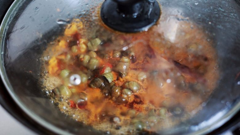 香辣螺蛳,螺蛳翻炒入味后锅里倒进一碗清水，翻炒几下后盖上锅盖用小火煮十几分钟让螺蛳熟透。