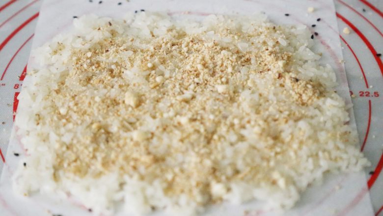 武汉小吃 糯米包油条,将打成粉的花生粉均匀的洒在铺好的糯米饭上。