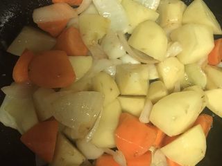 泰式椰浆咖喱牛腩,然后放入土豆胡萝卜煸炒，注意火候，不要炒糊。煸炒至土豆表面透亮。