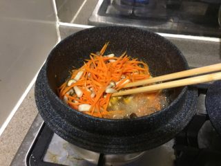 日式蔬菜拌豆腐,不断翻炒胡萝卜和蟹味菇，直到汤汁收干。