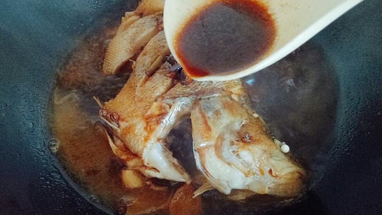 红烧鲈鱼,鱼熟后用勺子盛汤汁反复往鱼身上淋几次，把鱼盛出放盘子里。