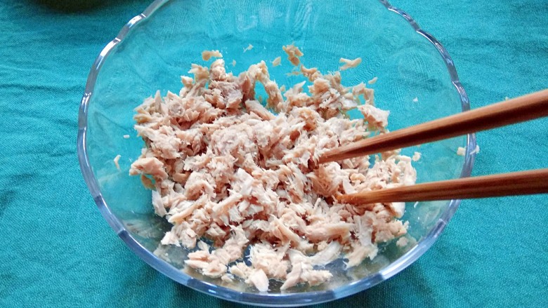 金枪鱼沙拉,把金枪鱼肉倒进一个大的沙拉碗，用筷子打散，放在一旁备用。