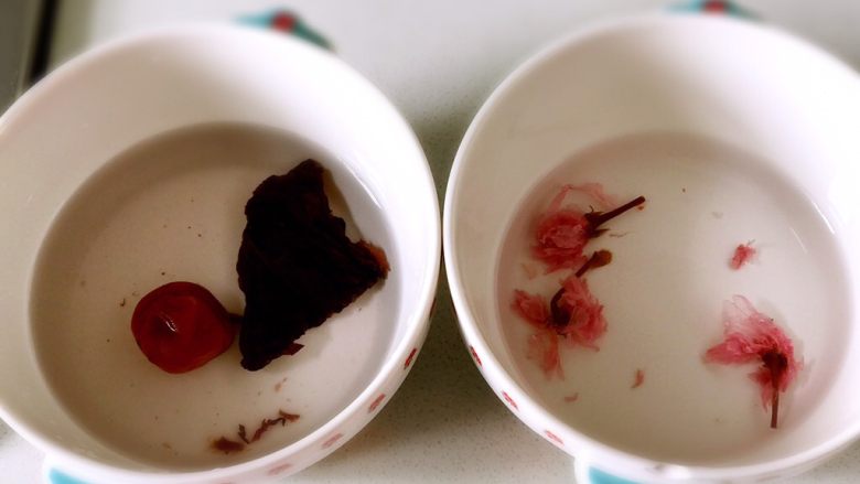 紫蘇酸梅櫻花飯團,將酸梅和鹽漬櫻花用清水泡一下去咸酸味兒，然後把酸梅去核切成碎，櫻花留兩朵剩下一並切碎備用。