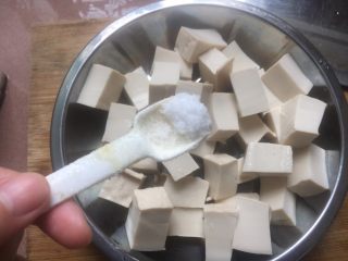 卤水豆腐,将切好的豆腐块装入盘中，并加入适量食盐腌制10分钟。